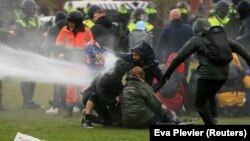Полицијата користи воден канон за време на протест против ограничувањата воведени за спречување на ширењето на коронавирусот, Амстердам, Холандија, 24 јануари 2021 година.