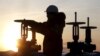 A worker checks the valve of an oil pipe at the LUKoil company-owned Imilorskoye oil field outside the western Siberian city of Kogalym.