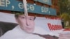 Қырғызстан президенттігіне кандидат Адахан Мадумаровтың жыртылған билборды. Нарын, 14 қазан 2011 жыл. (Көрнекі сурет)