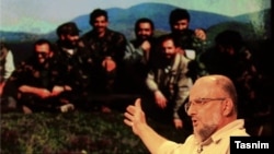 Iranian controversial conservative activist Saeed Ghasemi during an Interview with a photo in background showing him and his comrades during the Bosnian conflict in the early 1990s.