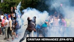 Protesters clash with members of the Bolivarian National Police during a demonstration against the Government of Nicolas Maduro in Caracas, January 23, 2019