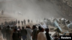 FILE: Displaced Afghan villagers gather near the site of a landslide in northeastern Afghanistan.