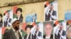 A man walks past posters of presidential candidates on a wall in Kabul.