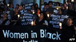 Indian activists belonging to various rights organizations hold placards and candles while they stage a demonstration in Bangalore condemning the recent gang-rape case.