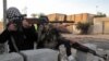 جندي ومقاتل عشائري يتخذان موقعاً خلال اشتباك مع مسلحي داعش في الرمادي