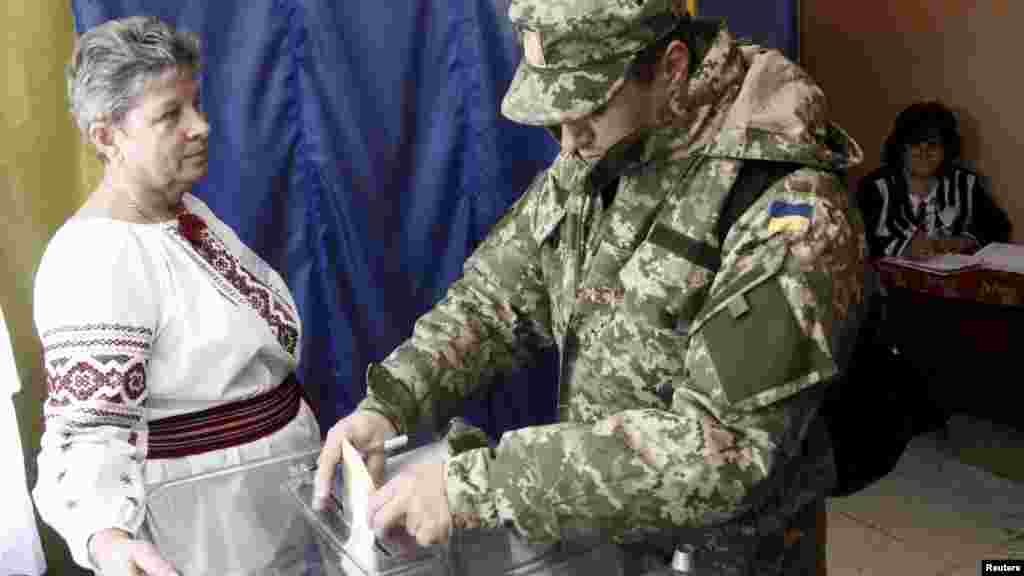 Український військовий під час голосування на виборчій дільниці неподалік Львов, 25 жовтня 2015 року &nbsp;
