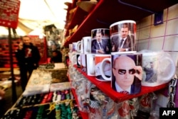 Căni cu chipul lui Putin vândute în Damasc, Siria.