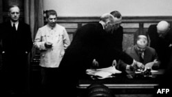 Германиянын тышкы иштер министри Иоахим фон Риббентроп (cолдо), советтик лидер Иосиф Сталин Москвада Молотов-Риббентроп пактына кол коюу маалында. 23-август, 1939-жыл. 