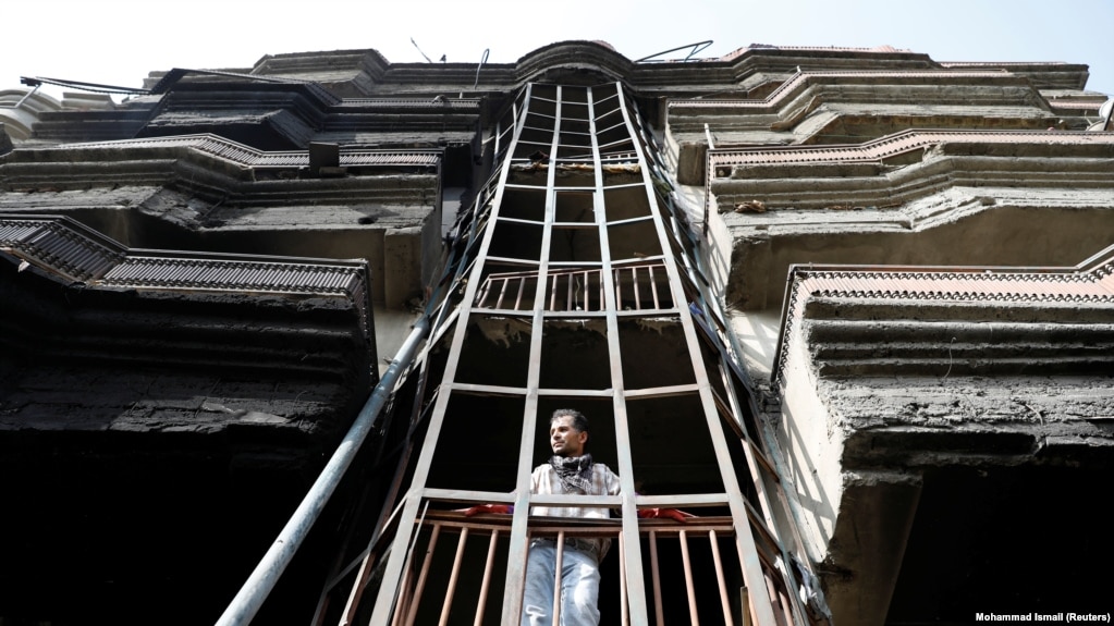 An Afghan man looks out from a damaged building after the July 28 attack in Kabul.