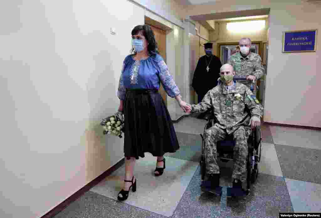 Ihor Ponomarchuk, a Ukrainian serviceman injured in the military conflict in the country&#39;s eastern regions, and his bride, Anna Diolomina, arrive for a wedding ceremony at the Main Military Clinical Hospital amid the coronavirus outbreak in Kyiv. (Reuters/Valentyn Ogirenko)