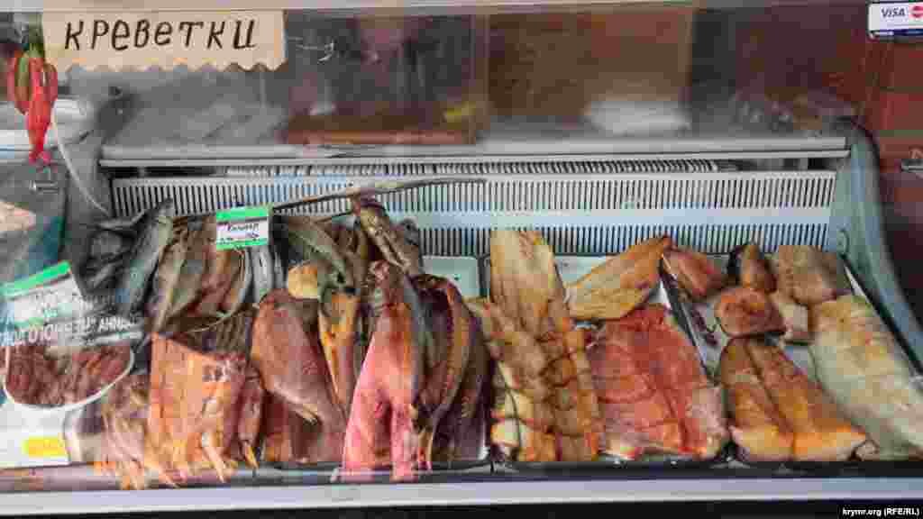 Продается также и закуска к пиву: кальмары, креветки и копченая рыба. В правом углу холодильника наклейка Visa и Mastercard &ndash; раньше на полуострове можно было рассчитаться кредитной карточкой