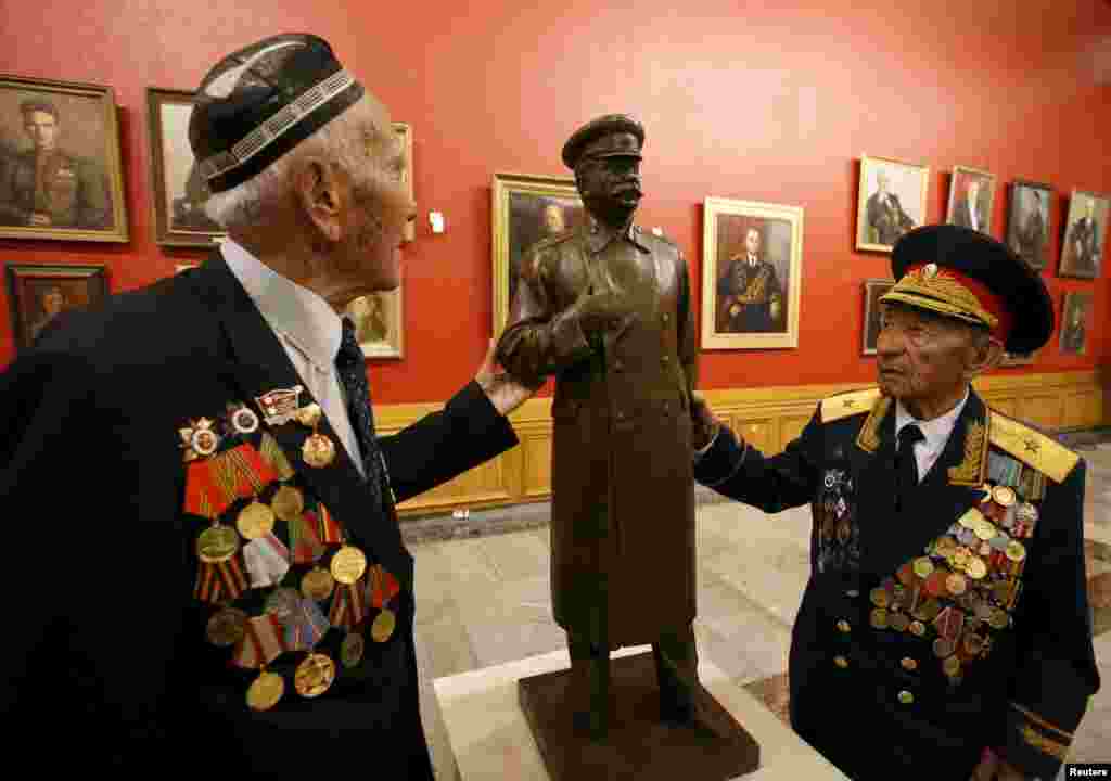 World War II veterans touch an exhibit showing Soviet leader Josef Stalin at the Central Museum of the Great Patriotic War in Moscow on April 28. (Reuters/Sergei Karpukhin)