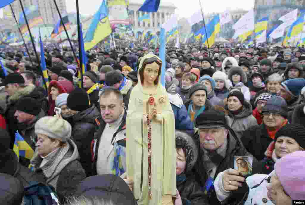 Pro-EU protesters hold up a statue of the Virgin Mary.