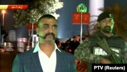 Indian pilot, Wing Commander Abhinandan, stands under armed escort near Pakistan-India border in Wagah late on March 1.
