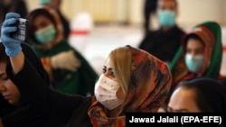 An Afghan girl wearing a face mask 