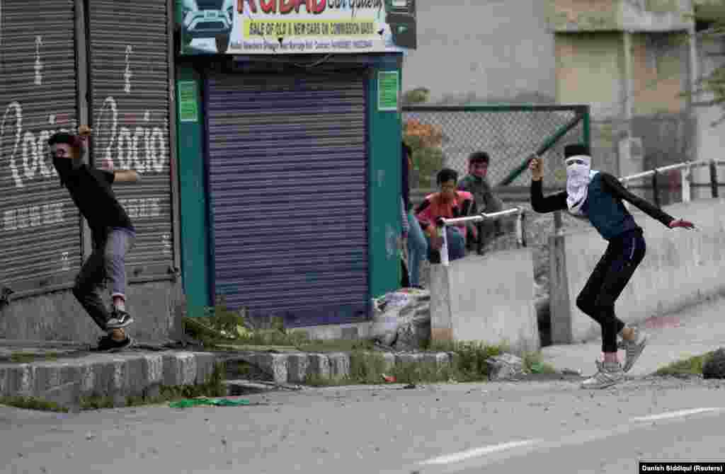 Kashmiri residents throw stones towards Indian security forces during restrictions after the scrapping of the special constitutional status for Kashmir by the government, in Srinagar on August 10.