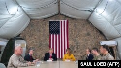 U.S. President Donald Trump and First Lady Melania Trump attend a military briefing during an unannounced trip to Al Asad Air Base in Iraq on December 26, 2018.
