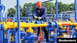 Ілюстративне фото: працівник обслуговує трубопроводи на родовищі газу та газоконденсату в Харківській області