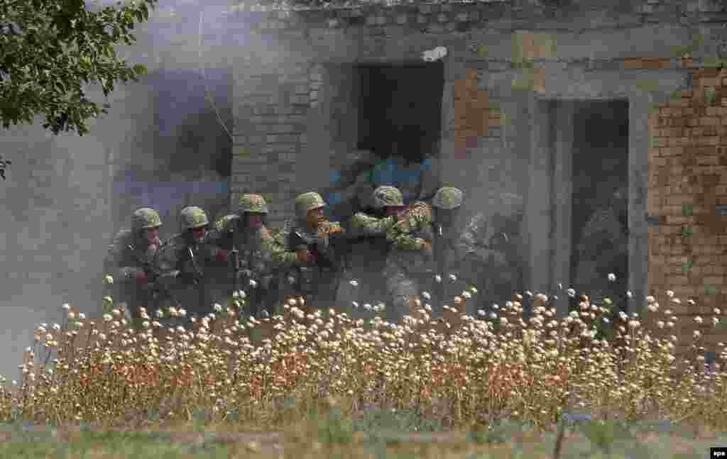 Georgian soldiers storm a building during a joint military exercise with NATO soldiers at the Vaziani military base outside Tbilisi. The Agile Spirit 2015 maneuvers gather troops from the United States, Georgia, Romania, Bulgaria, Lithuania, and Latvia. (epa/Zurab Kurtsikidze)