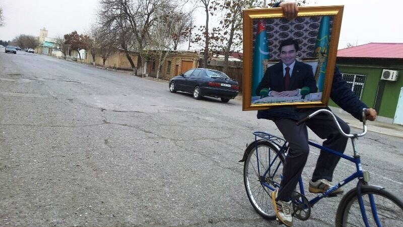Serdar Berdimuhamedowyň portretiniň gapdalyndan Gurbanguly Berdimuhamedowyň portreti asylýar