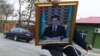 Türkmen prezidentiniň portretini tigirde göterip barýan bir oglan. Arhiwden alnan illýustrasiýa suraty.