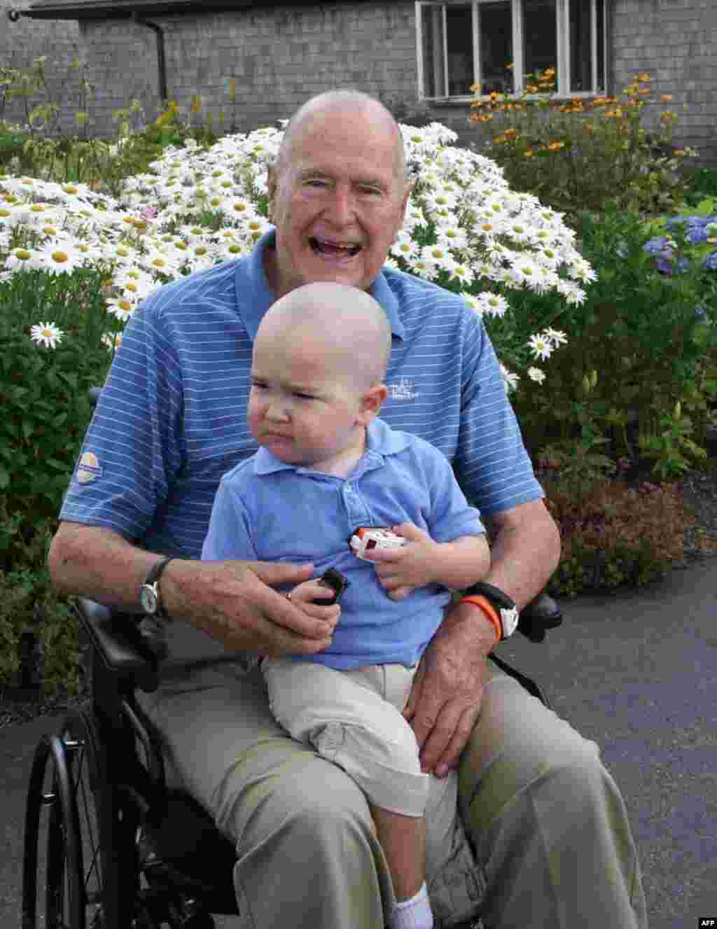 Former U.S. President George H.W. Bush poses in Maine with his head shaved to show support for 2-year-old Patrick, the son of one of Bush's security staff. His surname is being withheld at the family's request. Patrick has lost his hair from leukemia treatments. Some 26 other members of his security staff also shaved their heads. Bush and his wife, Barbara, lost a 4-year-old daughter, Robin, to leukemia nearly 60 years ago. (AFP/Office of George Bush)