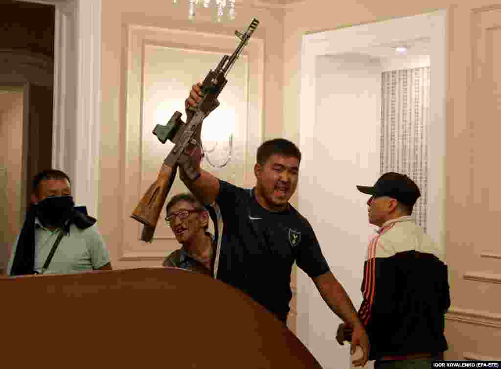 An Atambaev supporter wields a partly disassembled automatic weapon that appears to have been seized from special forces troops.