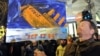 A man holds a banner with a sinking ship of the ruling Fidesz party in front of the state opera in Budapest on January 2.