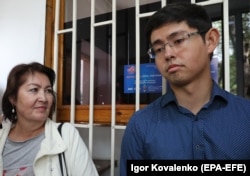 Raisa Atambaeva and her son Kadyr wait outside the State Committee for National Security in Bishkek on August 16.