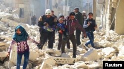 Banorët dhe pjesëtarët e mbrojtjes civile në Idlib i shpëtojnë fëmijët duke i larguar nga vendi i shkatërruar nga një sulm i mëparshëm ajror 