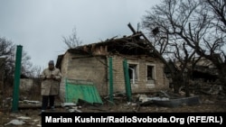 Жителька Авдіївки оглядає свій будинок, пошкоджений під час обстрілів, 27 березня 2017 року