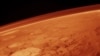 Space -- The tenuous atmosphere of Mars, visible on the horizon in this low-orbit photo, undated