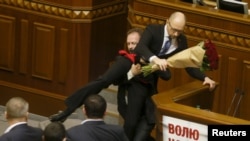 Народний депутат Олег Барна намагається винести прем’єр-міністра Арсенія Яценюка з-за трибуни під час засідання парламенту в Києві, 11 грудня 2015 року 