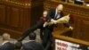 Ukraine -- Parliament deputy Oleh Barna tries to remove Prime Minister Arseniy Yatsenyuk from the tribune, after presenting him a bouquet of roses, during a parliament session in Kyiv, December 11, 2015