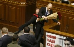 Депутат Олег Барна намагається прибрати від трибуни прем'єра Арсенія Яценюка. Цей кадр став практично легендарним