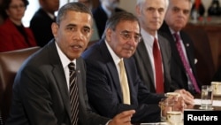 U.S. President Barack Obama (left) is flanked by Defense Secretary Leon Panetta as he speaks at a Cabinet meeting in Washington in late January.