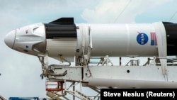 Техници работят по SpaceX Crew Dragon, прикачен за ракетата Falcon 9 в космическия център "Кенеди" във Флорида