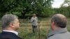 Georgia -- Georgian President Giorgi Margvelashvili (R) and Ukrainian President Petro Poroshenko speak to a local resident behind a razor-wire topped fence during a visit to the village of Akhali-Khurvaleti on the administrative border with the Georgian b