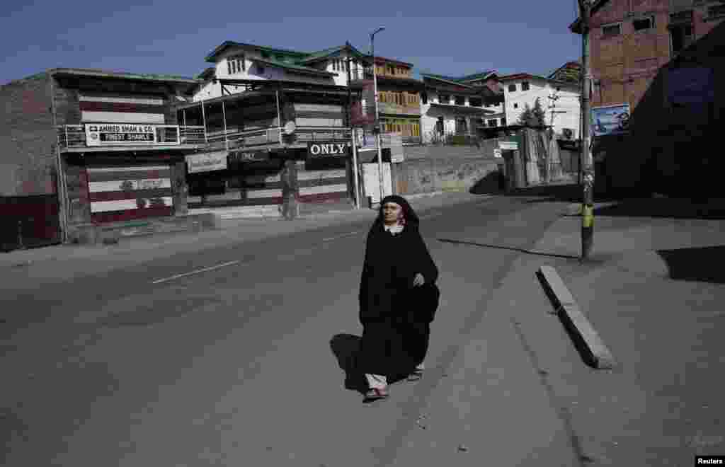 Një grua nga Kashmiri ecë në rrugët e boshatisura.&nbsp;