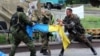 "Чыгыш" деген орусиячыл батальондун аскерлери Донецктеги өкмөттүк имарат алдында украин желегин айрып жатышат, 29-май, 2014