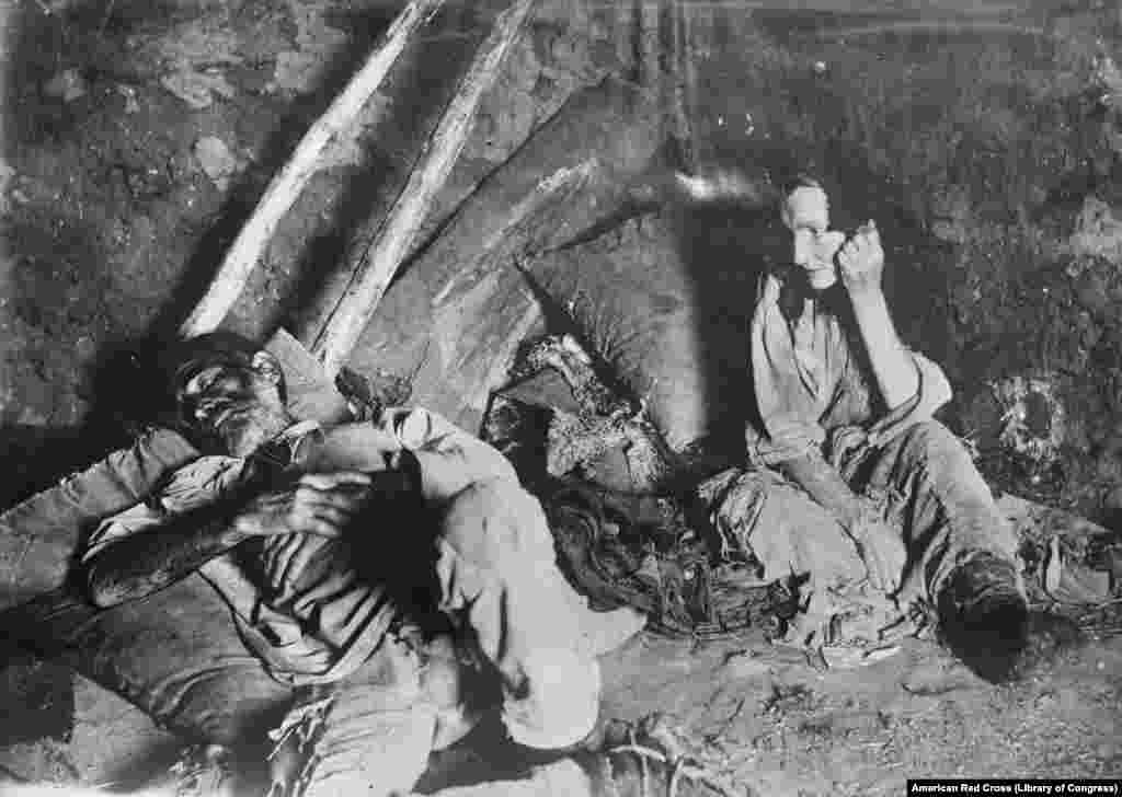 A woman in Russia's Samara region looks helplessly at her dying husband in 1921. These are some of a remarkable series of images taken by unidentified photographers of the American Red Cross during expeditions into Russia as civil war and an ensuing famine ravaged the country a century ago.