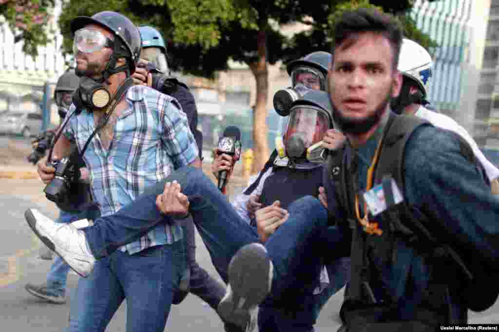 An injured reporter is carried away during a rally against the government of Venezuela's President Nicolas Maduro in Caracas on May 1. (Reuters/Ueslei Marcelino)
