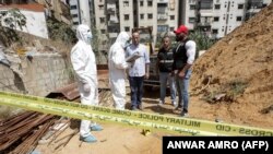 This picture taken on August 25, 2019 shows forensic investigators of Lebanon's military intelligence inspecting the scene where two drones came down in the vicinity of a media center of the Shiite Hezbollah movement earlier in the day in Beirut's southern suburbs.