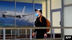 Пассажир в медицинской маске в аэропорту.