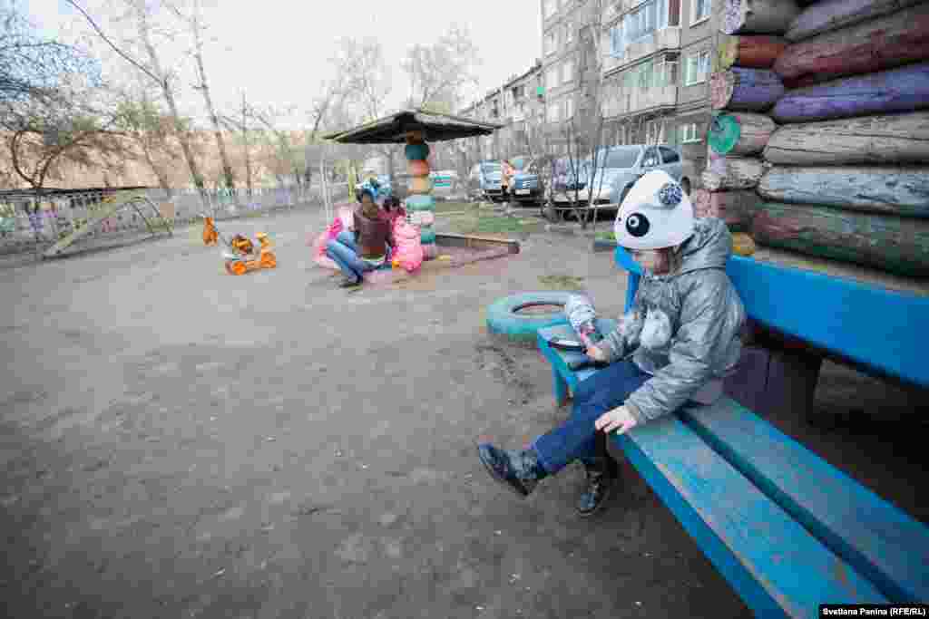 Vera sits on a bench at a playground. She longs for contact with other children, but the adults perceive her odd behavior as misbehavior. After her condition is explained to them, they usually tell Alena, &quot;You should stay home.&quot;