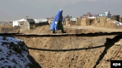 Кабулдың шетінде жыра үстіндегі көпірмен өтіп бара жатқан пәренжі киген әйел. 2 қаңтар 2014 жыл. (Көрнекі сурет.)