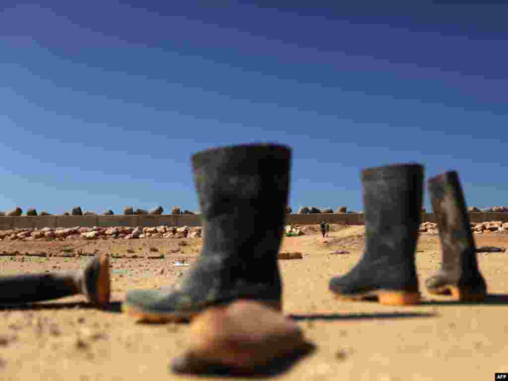 Boots abandoned by foreign workers next to a makeshift camp near the Libyan port of Benghazi on February 28. Photo by Patrick Baz for AFP