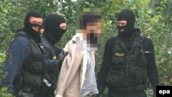 Police officers lead away a suspected terrorist in Vienna in September, 2007