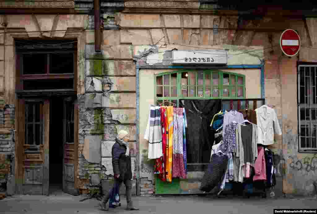 A woman walks by a second hand shop in Tbilisi, Georgia. (Reuters/David Mdzinarishvili)