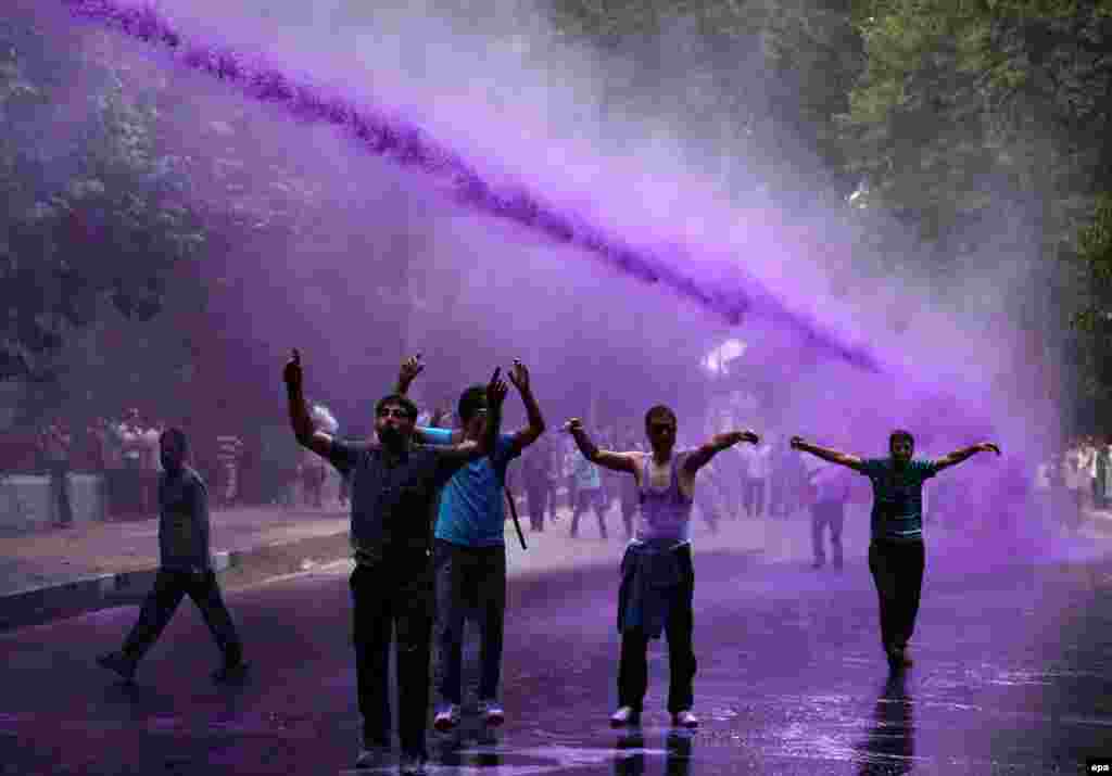 Kashmiri government employees shout slogans as Indian police spray purple-colored water to disperse them during a protest march in Srinagar, the summer capital of Indian Kashmir. Government employees have been demanding regularization of their jobs and release pending salaries. (epa/Farooq Khan)